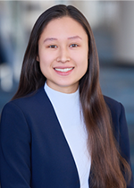 Headshot of student smiling at camera with long dark brown straight hair falling over left wearing navy blazer over white shirt