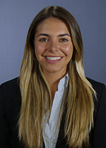 Student smiling at camera with dyed blonde hair over shoulders wearing black blazer over white shirt