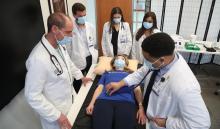 Duke medical students practice clinical skills on a pretend patient.