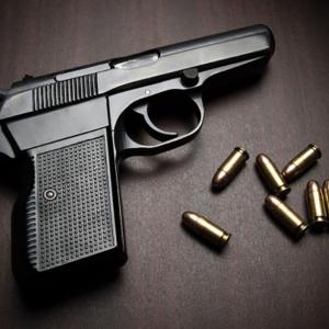 handgun and bullets laying on a table. 
